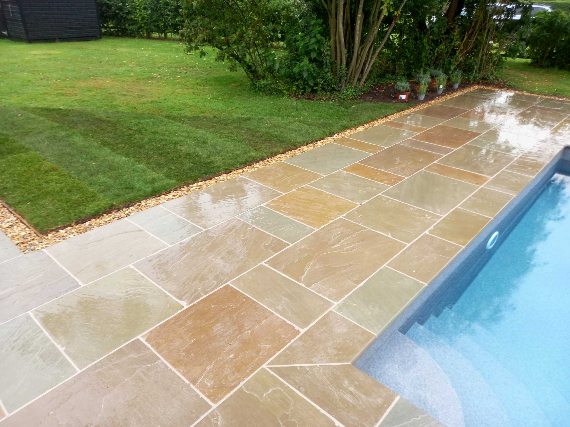 Swimming pool finished with natural stone paving and coping stones